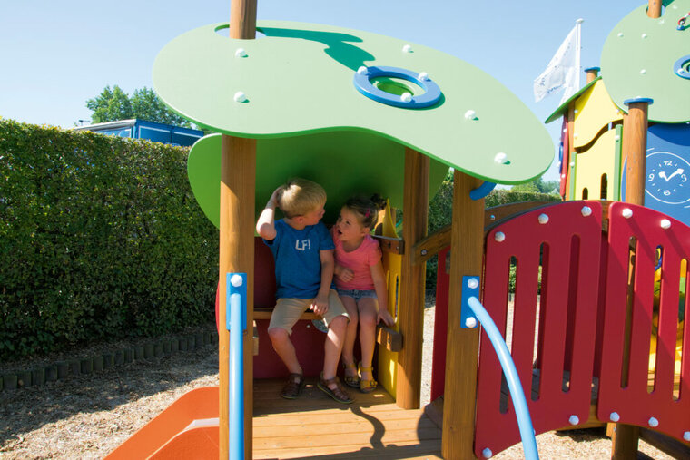 sfeerfoto van 2 kindjes die in de lagere speeltoren van het Europlay Speeltoestel Blauwbaard zitten