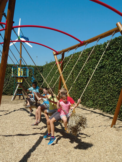 sfeerfoto met kinderen op de Europlay Houten Familieschommel Openbaar vanaf de zijkant een foto gemaakt