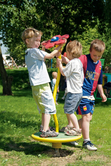 sfeerfoto met kinderen die aan het spelen zijn op de Europlay Draaimolen Dansende Bloem Openbaar