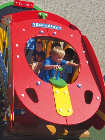 sfeerfoto van de voorkant van de Europlay Express Speeltrein met tunnel waar een jongetje met de besturingshendel speelt