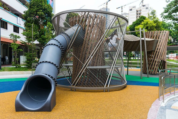 sfeerfoto van de Kunststof buisglijbaan Openbaar Gebruik geplaatst op een speelplaats buiten kleur antraciet