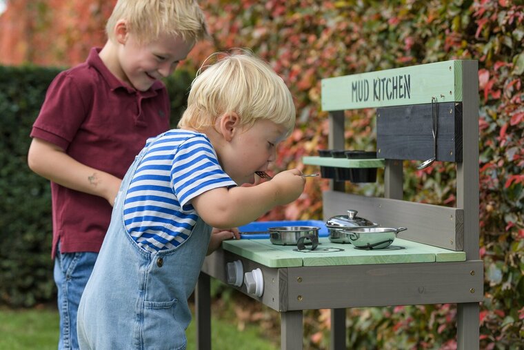 twee kinderen spelen met Mud Kitchen