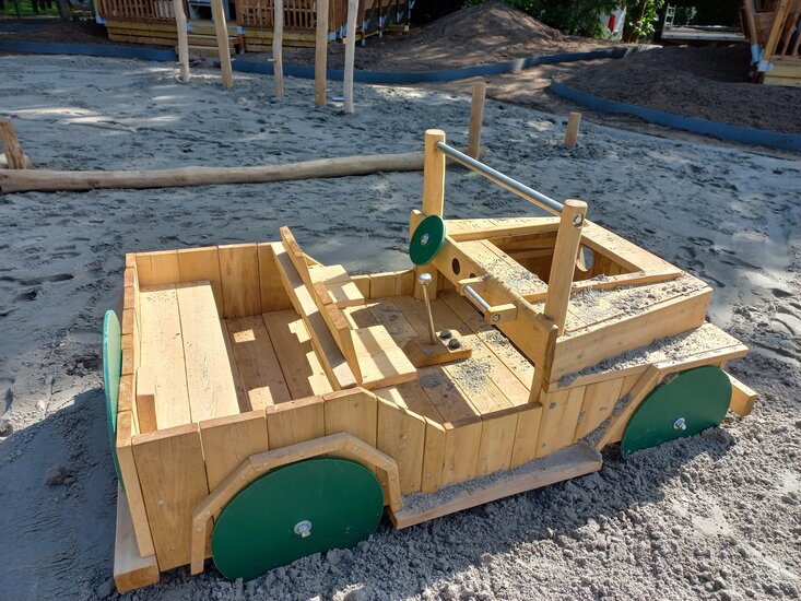 Zijkant van Robinia houten jeep met groene wielen