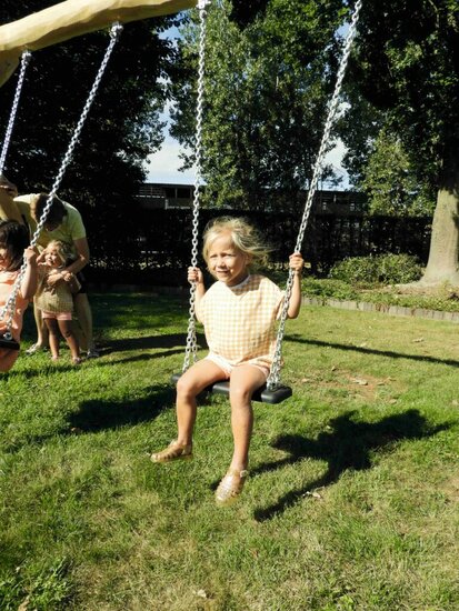 kind schommelt in de zon op Eco-Play Kleine Robinia Schommel