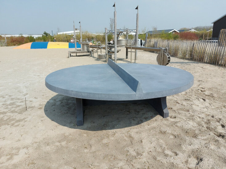 Betonnen tafeltennistafel Rond Antraciet-Beton op het strand