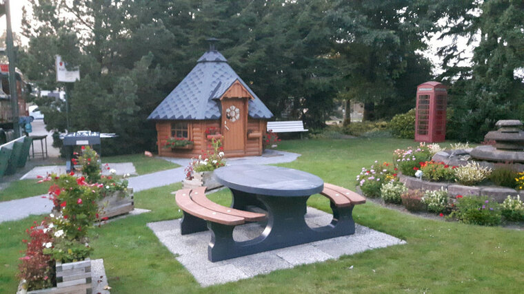 Betonnen Picknickset DeLuxe Ovaal Antraciet Gelakt met Bamboe Zitvlak in tuin bij tuinhuisje