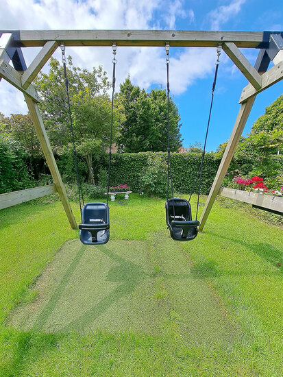 grijs en zwart babyzitje aan schommelframe