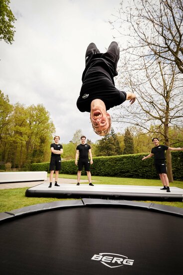 BERG mood afbeelding van Salto makende tiener met andere tieners kijkend op de Elite trampoline