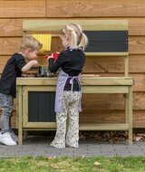 kinderen buitenspelen met zand en water in keuken