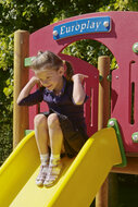 sfeerfoto van de kunststof glijbaan van de Europlay Speeltoren Glijtoren waar een kind op speelt