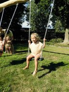 kind schommelt in de zon op Eco-Play Kleine Robinia Schommel