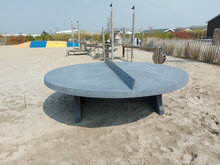 Betonnen tafeltennistafel Rond Antraciet-Beton op het strand