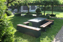 Betonnen Picknickset DeLuxe met Bamboe Zitvlak en Antraciet Gelakt met antracieten banken in een tuin