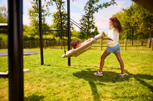 kinderen schommelen met berg nestschommel die hangt aan berg playbase