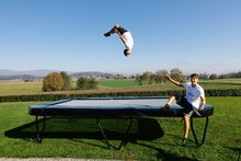 jongen doet salto op Akrobat Trampoline Primus Challenger PLUS 430x305 cm met veiligheidsnet